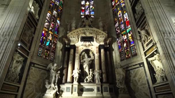 Kamenný oltář se sochou sv. Giovanniho na pozadí vitrážových oken v Duomu. Itálie, Milan — Stock video