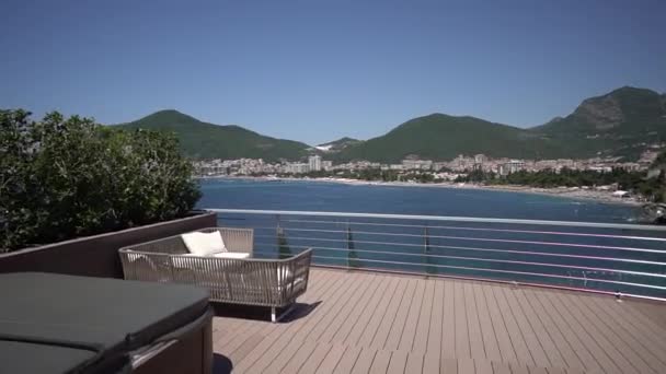 Widok z drewnianego tarasu hotelowego do zatoki i wybrzeża Budvy — Wideo stockowe