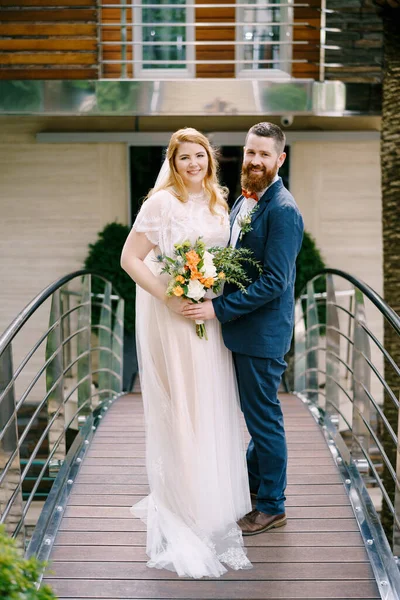 Νύφη και γαμπρός στέκονται στη γέφυρα του ξενοδοχείου — Φωτογραφία Αρχείου