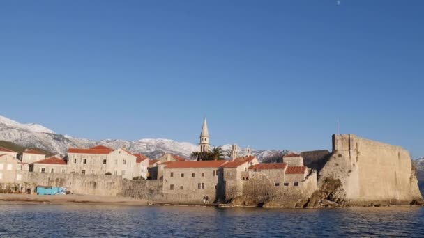 Stare miasto Budva na tle ośnieżonych gór. Widok z morza — Wideo stockowe