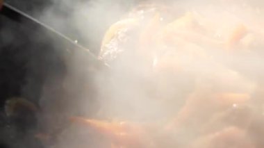 Kazanda slotlu kaşıkla Özbek pilavını karıştırmak