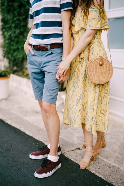 Чоловік з жінкою тримає руки, стоячи на вулиці — стокове фото