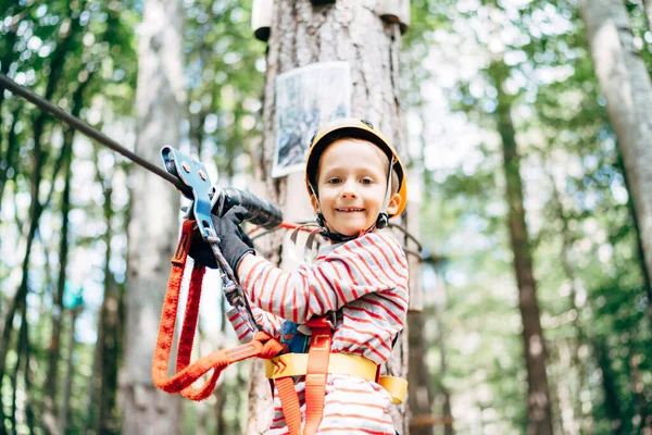 Junge mit Helm und Sicherheitsseil steht auf Holzplattform — Stockfoto