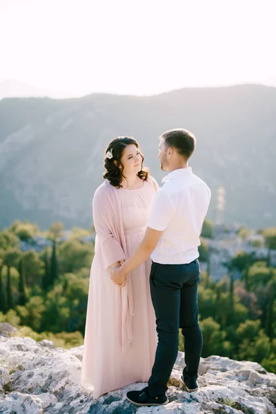 Mariée et marié se tiennent debout sur les pierres sur le fond des montagnes — Photo