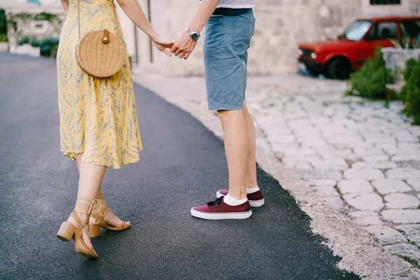 Guy holds the girl hand while standing on the pavement — Stock Photo, Image