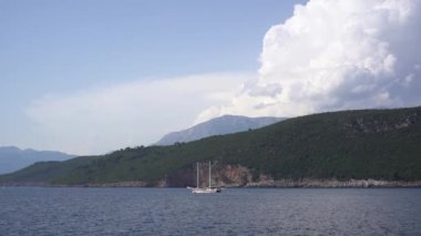 Yelkenli Kotor körfezi boyunca yeşil dağların arka planına doğru yelken açar.