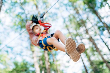 Çocuk emniyet kemerinde otururken halatla iniyor.