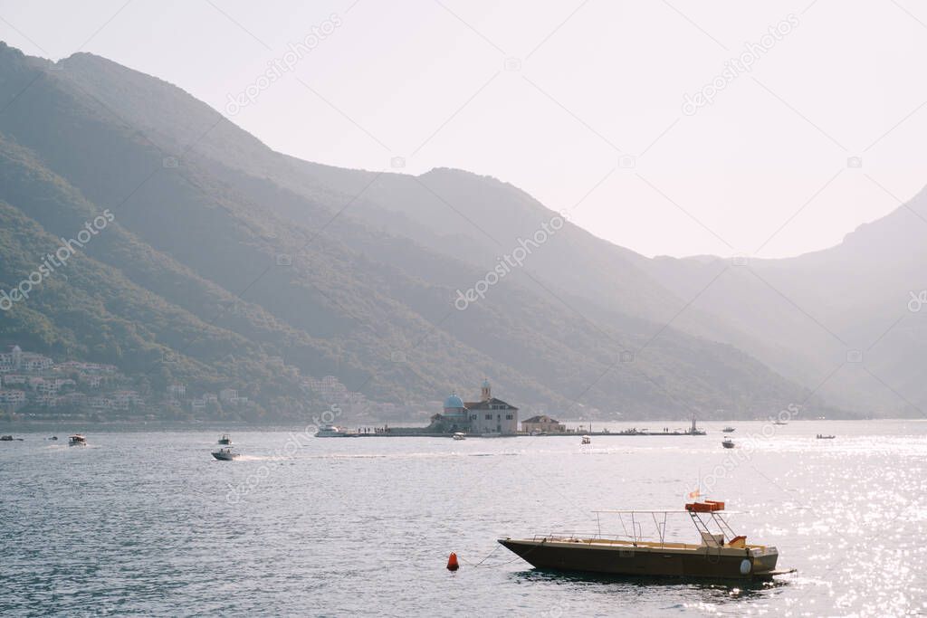 Boat is moored in the bay against the backdrop of the island of Gospa od Skrpjela. Montenegro