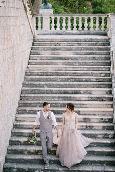 Наречена і наречений спускаються кам'яними сходами вілли — стокове фото