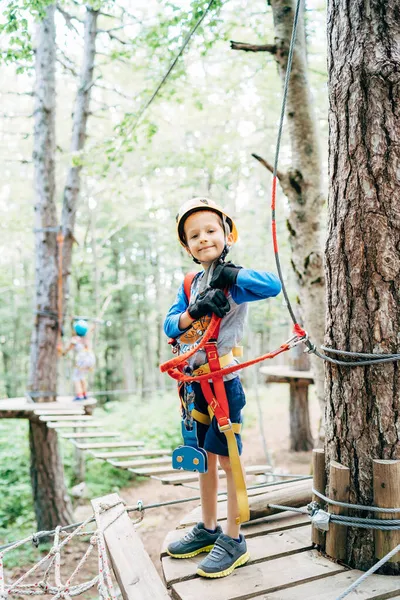 Chłopiec stoi na drewnianej platformie w bezpiecznym sprzęcie w parku rozrywki — Zdjęcie stockowe