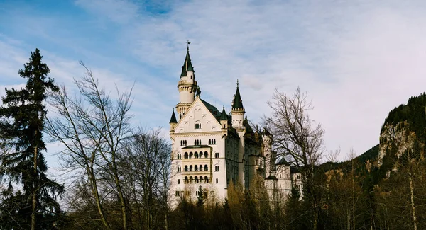 Märchenhaftes Schloss Neuschwanstein zwischen Bäumen. Deutschland — Stockfoto