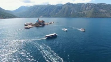 Gospa od Skrpjela adasından motorlu tekneler yola çıkıyor.