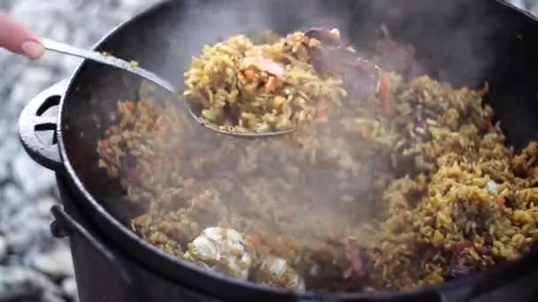 用开槽勺子从大锅里捞起最后一块乌兹别克皮 — 图库视频影像