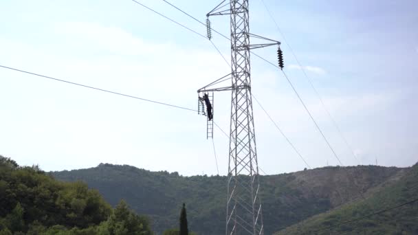 Ηλεκτρολόγος επισκευάζει ένα καλώδιο ρεύματος στα βουνά — Αρχείο Βίντεο