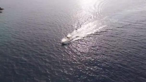 Blick von einer Drohne auf ein weißes Motorboot, das auf dem Meer segelt — Stockvideo