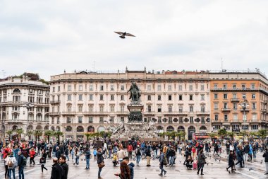 İnsanlar Victor Emmanuel II anıtının önünde Piazza Duomo boyunca yürüyorlar. Milan, İtalya