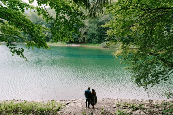 Hombre y mujer de pie en la orilla de un lago en el parque Biogradska Gora. Vista trasera —  Fotos de Stock