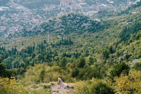 신부와 신랑은 산에서 마을을 바라보며 포옹 한다. 공중에서 본 광경 — 스톡 사진
