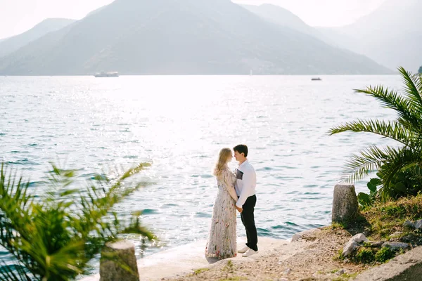 Sposa e sposo si trovano sulla strada Perast sullo sfondo delle montagne. Montenegro — Foto Stock