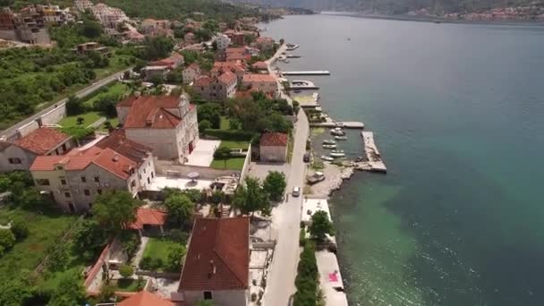 Vue par drone de la ville au bord de la mer entre montagnes et verdure — Video