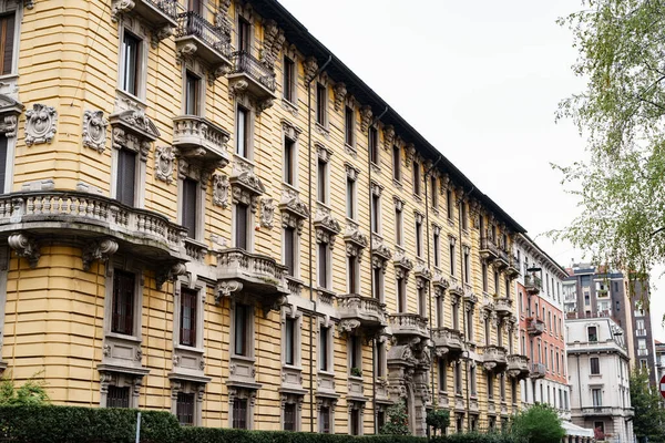 Fasada starego domu z rzeźbionymi kamiennymi balkonami i sztukateriami. Mediolan, Włochy — Zdjęcie stockowe