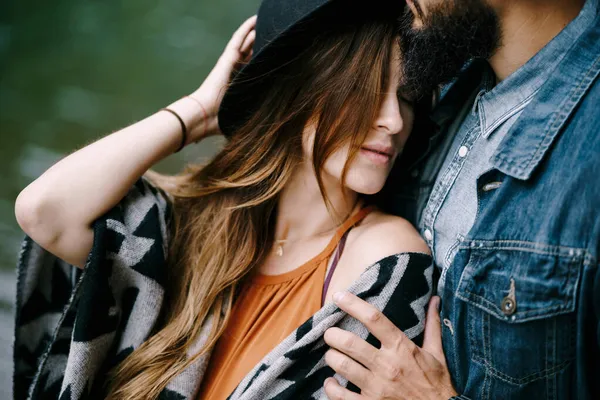 De man knuffelt de schouders van een vrouw met een hoed. Portret — Stockfoto