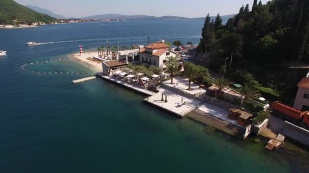 Chorwackie wybrzeże z piaszczystą plażą, leżakami, palmami i domami — Wideo stockowe