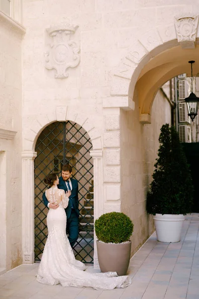 Pengantin pria dengan pengantin wanita di halaman rumah dengan lengkungan dekat gerbang dekoratif logam — Stok Foto