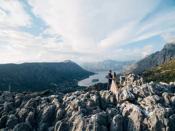 Bräutigam und Braut stehen auf dem Berg mit Blick auf das Tal der Bucht von Kotor — Stockfoto