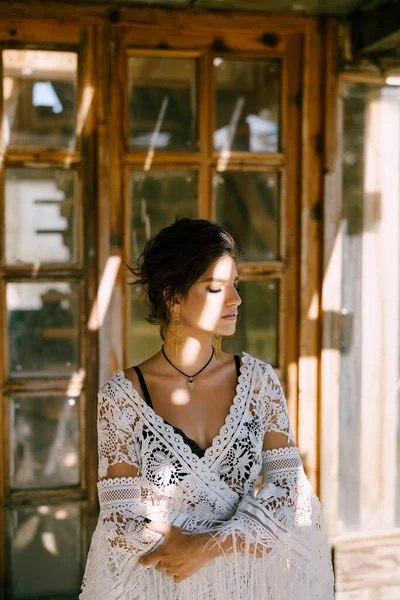 Kobieta w białej koronkowej pelerynie siedzi w pobliżu zabytkowych drewnianych drzwi. Portret — Zdjęcie stockowe