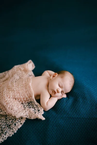 Naked baby covered with shawl sleeps on blanket — Stock Photo, Image