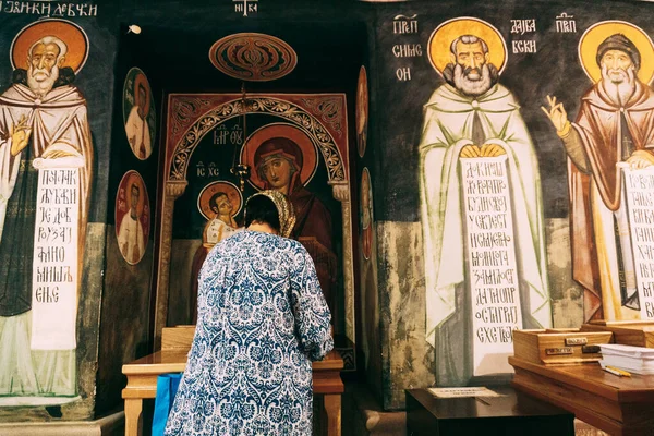 Una donna prega davanti alle icone del monastero di Ostrog. Montenegro — Foto Stock