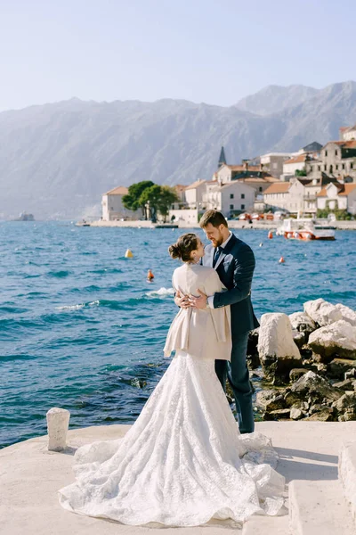 Menyasszony és vőlegény ölelés a háttérben a part Perast. Montenegró — Stock Fotó