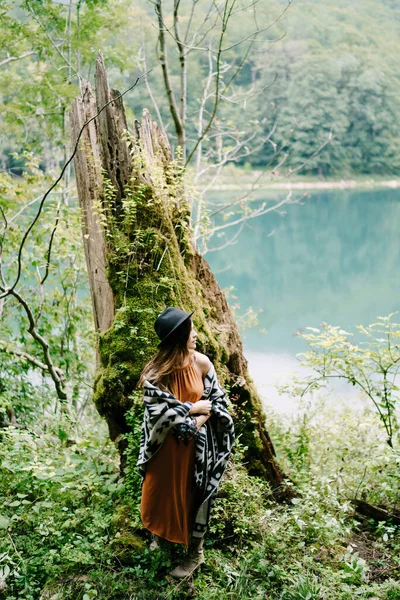 Mujer parada cerca de un árbol cubierto de musgo junto al lago —  Fotos de Stock