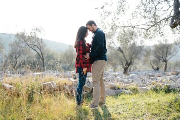 Uomo che si tiene per mano la pancia della donna incinta mentre in piedi nel parco — Foto Stock