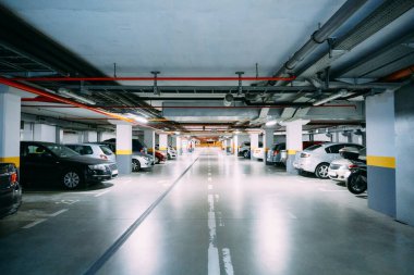 Birçok araba yeraltı otoparkında ışıklandırmalı duruyor.
