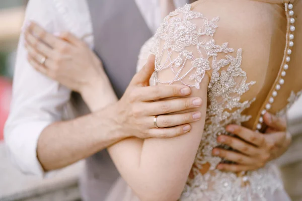 Αγκαλιάστε τον γαμπρό και τη νύφη με δαντελωτό φόρεμα. Κοντινό πλάνο — Φωτογραφία Αρχείου