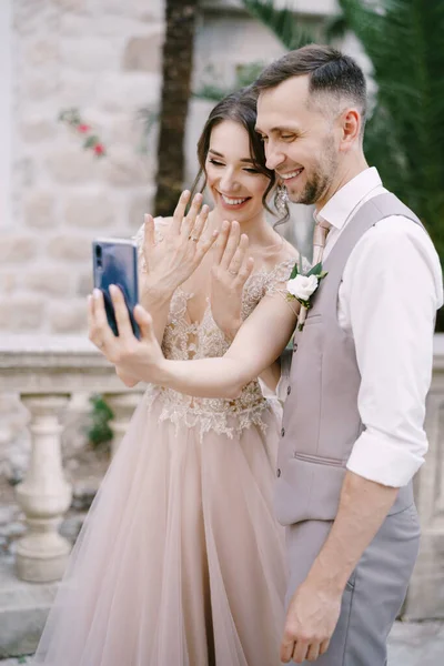 Gelin ve damat parmaklarında yüzüklerle bir selfie çekerler. — Stok fotoğraf