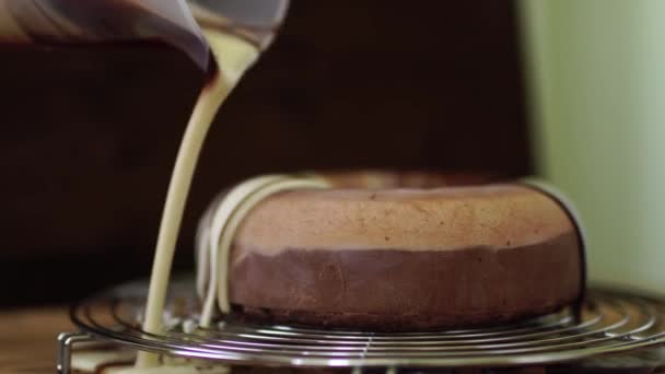 Pastry chef is pouring marble mirror glaze on a mousse chocolate cake — Stock Video