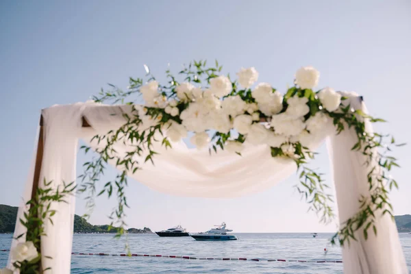 Fragment av en bröllopsbåge dekorerad med vit tyll och blommor — Stockfoto