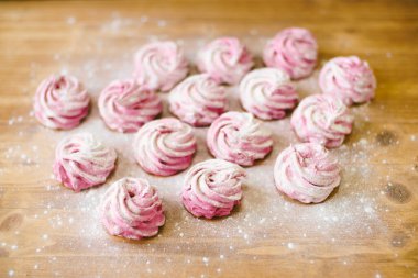 Masanın üzerinde pudra şekerli pembe şekerlemeler var.