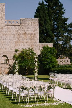 Düğün kemeri, sandalyenin önündeki tuğla duvarın yanında duruyor.