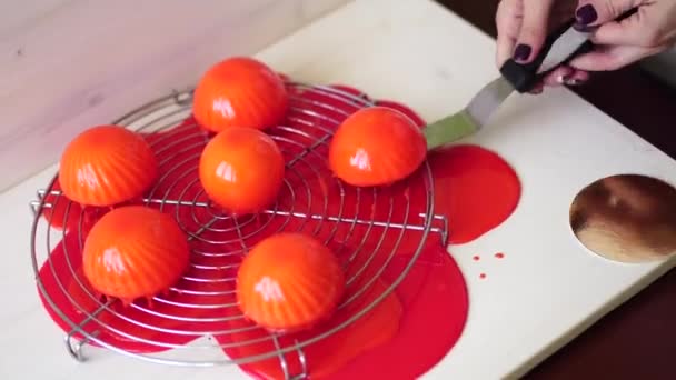 Шеф-повар удаляет излишки глазури из тортов лопаткой и ножом — стоковое видео