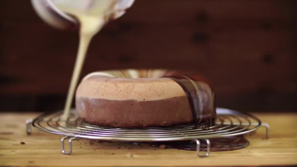 Banketbakker schenkt chocolade spiegel glazuur op de mousse cake — Stockvideo