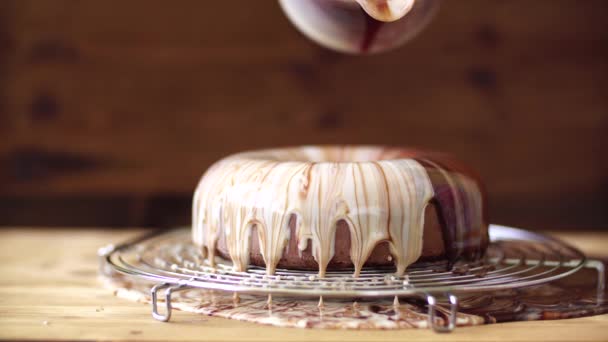 Banketbakker giet witte en bruine chocolade glazuur op de mousse cake — Stockvideo