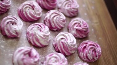 Ahşap masada pudra şekerli pembe böğürtlen şekeri. Üst görünüm