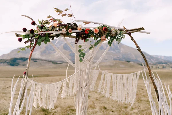 Lengkungan pernikahan dihiasi dengan macrame, bunga dan cabang berdiri di lapangan — Stok Foto