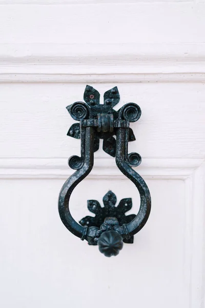 Forged metal knob on a white wooden door. Close-up — Fotografia de Stock