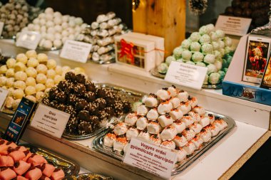 Çok renkli badem ezmeleri bir pastanenin tezgahındaki slaytlarda yatıyor.