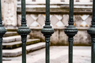 Dekoratif küresel eklentileri olan antika işlemeli demir çitler.